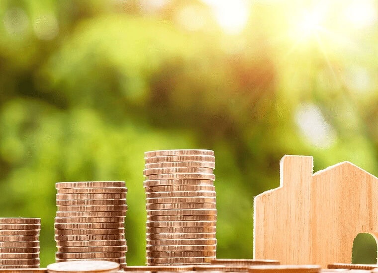 Stacks of quarters next to a small wooden house