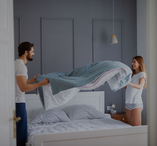 Couple making bed.