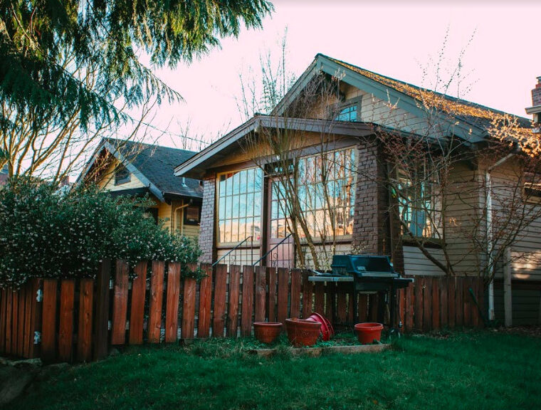 house and backyard with bbq and fence