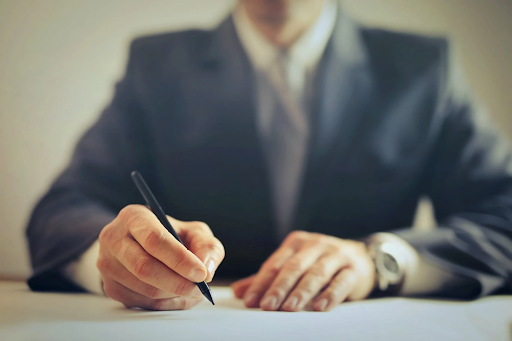 man in suit signing a contract