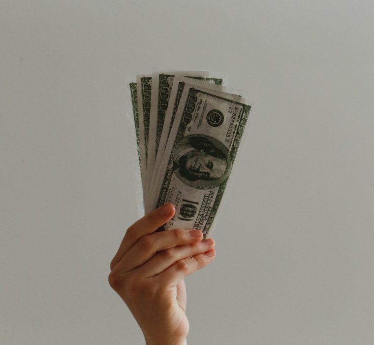 hand holding up hundred dollar bills USD